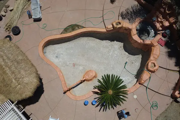 Vista aérea de la piscina reducida a su estructura desnuda, con los escombros ya retirados